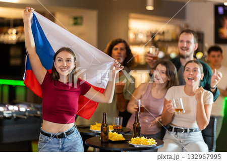 Men and women supporting Czech sports team in pub together. Group of friends raising Czech flag Men and women supporting Czech sports team in pub together. Group of friends raising Czech flag 132967995