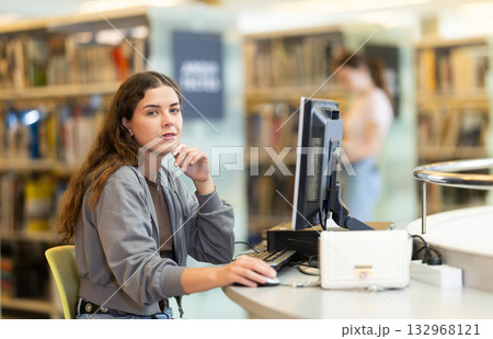 Female student working on computer in library 132968121