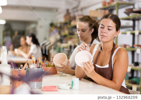 Girl painting with brush on handmade ceramic bowl Girl painting with brush on handmade ceramic bowl 132968209