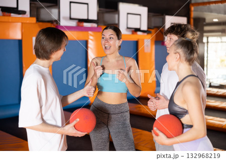 Young people in sport clothes talking merrily in trampoline arena 132968219
