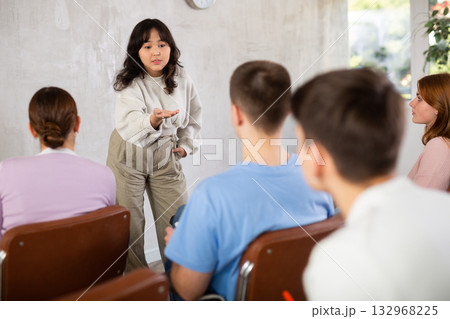 Asian girl student presenting report to fellow students 132968225