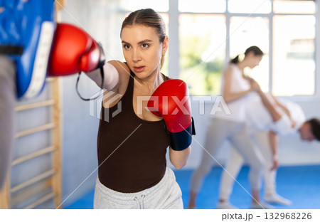 Young woman training in boxing fight in studio 132968226