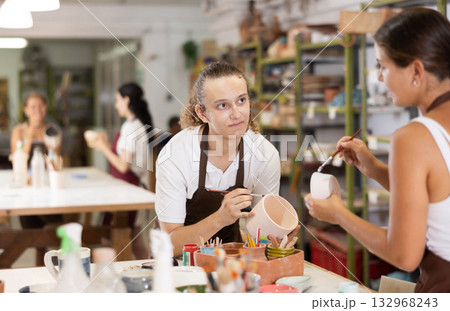 Young girl and guy painting with brush on handmade ceramic bowl 132968243