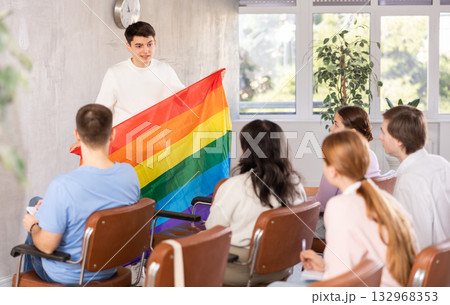 Young male professor showing rainbow flag to group of students 132968353