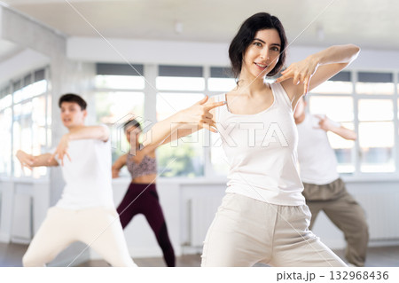 Positive woman learning modern street dance in studio Positive woman learning modern street dance in studio 132968436