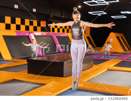 Adult woman trains jumping in trampoline center 132968460