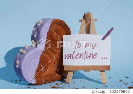 TO MY VALENTINE caption greeting card holiday present gift Valentine's Day Heart shaped blueberry flavor croissant on blue background with copy space. Puff pastry new trendy sweet dessert bakery TO MY VALENTINE caption greeting card holiday present gift Valentine's Day Heart shaped blueberry flavor croissant on blue background with copy space. Puff pastry new trendy sweet dessert bakery 132970699