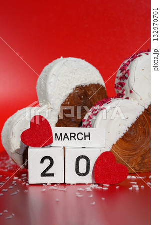 20 march International Day of Happiness Heart shaped coconut flavor croissant on red background with copy space. Puff pastry new trendy sweet dessert bakery. Creamy dough 132970701
