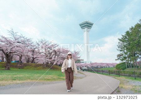 Woman tourist sightseeing Goryokaku Tower park with Sakura Cherry Blossom in Spring, happy traveler travel in Hakodate city, Hokkaido, Japan. famous Landmark, Japan Travel and Vacation destination 132971025