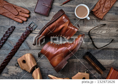 木製テーブルの上のウィングチップブーツと小物 132971626