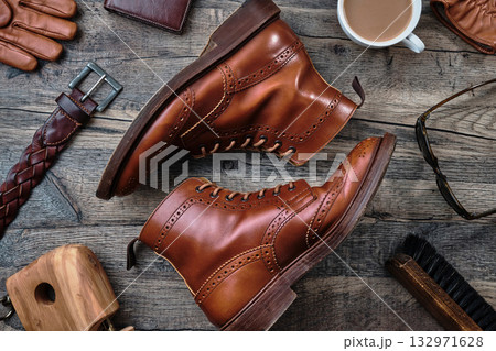 木製テーブルの上のウィングチップブーツと小物 132971628