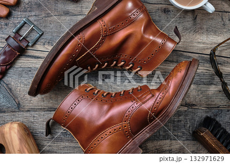 木製テーブルの上のウィングチップブーツと小物 木製テーブルの上のウィングチップブーツと小物 132971629