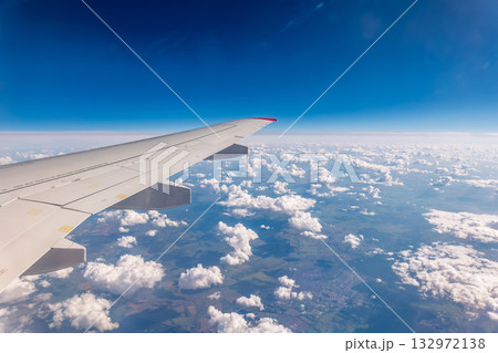 View from the airplane window at a beautiful cloudy sky and the airplane wing View from the airplane window at a beautiful cloudy sky and the airplane wing 132972138