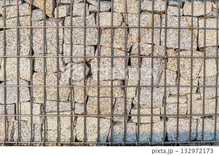 Modern Gabion Wall From Rocks And Stones In Metal Wire Box. Reinforcement and Abutment Protective Construction Modern Gabion Wall From Rocks And Stones In Metal Wire Box. Reinforcement and Abutment Protective Construction 132972173