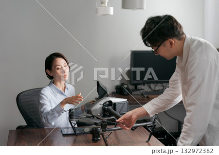 ドローンの操作説明を受ける女性 132972382