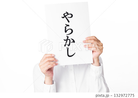やらかしと書かれた紙を持つ白いシャツを着た人物 やらかしと書かれた紙を持つ白いシャツを着た人物 132972775
