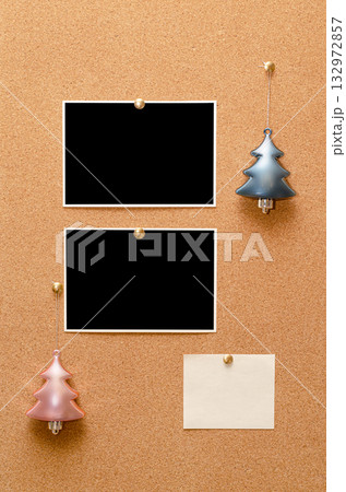Empty photos and Christmas tree toys are pinned on a cork board. Copy space 132972857
