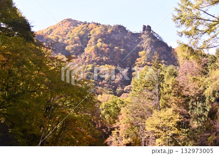 山上に奇岩の見える紅葉した山肌 132973005
