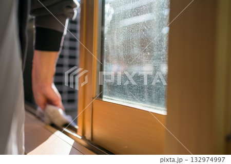 窓サッシのレールを掃除する主婦 132974997
