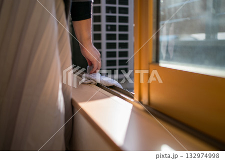 窓サッシのレールを掃除する主婦 132974998