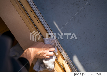 窓サッシのレールを掃除する主婦 132975002