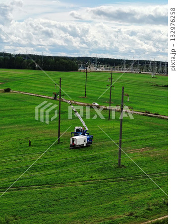 Aerial work platform truck repairing power lines. Aerial work platform truck repairing power lines. 132976258