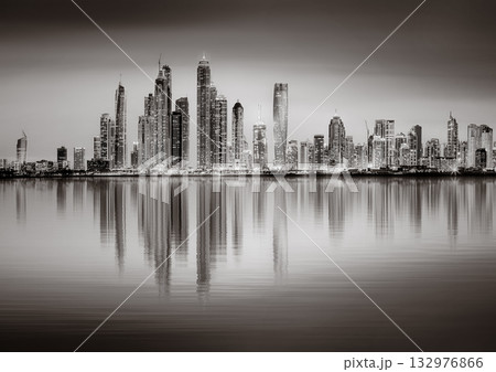 Urban city skyline with illuminated skyscrapers and waterfront railing in black and white at night, Dubai Marina bay UAE Urban city skyline with illuminated skyscrapers and waterfront railing in black and white at night, Dubai Marina bay UAE 132976866