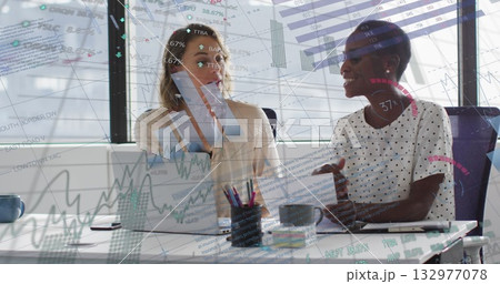 Analyzing charts business analysts discussing at office with laptop, papers, pens and coffee mugs 132977078