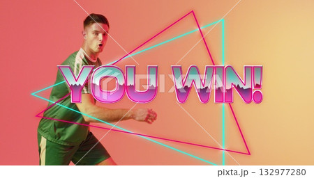 Reacting green-shirt athlete celebrating win in studio, with neon triangles, YOU WIN!, copy space Reacting green-shirt athlete celebrating win in studio, with neon triangles, YOU WIN!, copy space 132977280