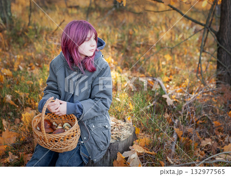 Young girl holding mushroom basket in autumn forest Young girl holding mushroom basket in autumn forest 132977565