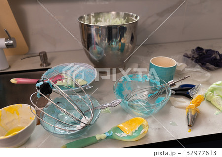 Messy Kitchen Scene With Bowls and Utensils From Baking Meringue and Whipped Cream 132977613