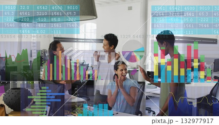 Celebrating success, four professional women cheering around office desk, with data chart overlays 132977917