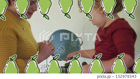 Mother and son preparing vegetables in kitchen, with blue colander and cutting board 132978343