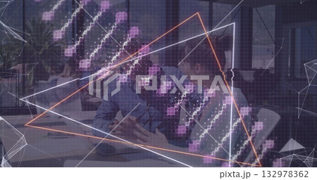Reviewing printed documents, business professionals pointing at laptop in office, with data overlay 132978362