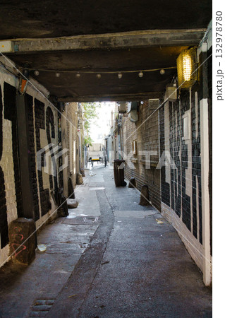 An alleyway in Dublin, Ireland, with brick walls and graffiti. The scene is illuminated by natural light. 132978780
