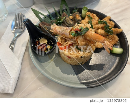 Stir Fried Chili Basil leaves with prawns on rice in a restaurant 132978895