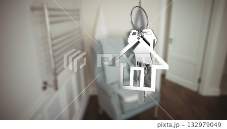 Hanging house-shaped keychain showing silver keys in home entryway, armchair, towel radiator 132979049