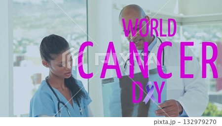 Nurse and doctor in medical uniforms reviewing imaging film in clinic, with World Cancer Day ribbon 132979270