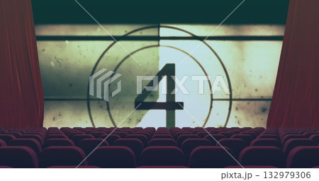 Displaying vintage countdown number 4 on projection screen in theater, with red curtains and seats 132979306