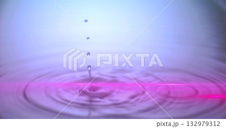 Hovering water droplet creating ripples on liquid surface at studio, with neon-pink reflection line 132979312