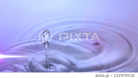 Suspending clear water droplet above studio pool, showing thin water column and circular ripples 132979316