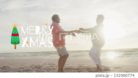 Dancing senior couple holding hands on sandy beach at sunset, with Merry Xmas tree overlay Dancing senior couple holding hands on sandy beach at sunset, with Merry Xmas tree overlay 132980774