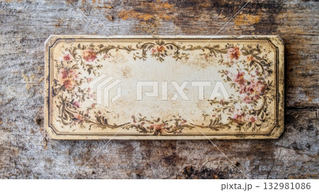 Vintage floral design plaque placed on rustic wooden surface surrounded by weathered textures and timeless charm 132981086