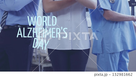 Three colleagues standing in ward, crossing arms with tie, white coat, scrubs, Alzheimer's overlay 132981662