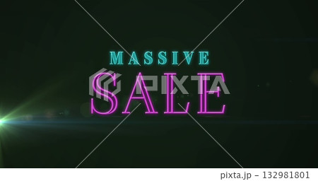 Glowing neon MASSIVE SALE text shining on dark electronic display, with greenish lens flare effect 132981801
