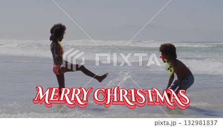 Splashing siblings playing in shallow ocean water, with bikini striped swim trunks and snorkel mask 132981837