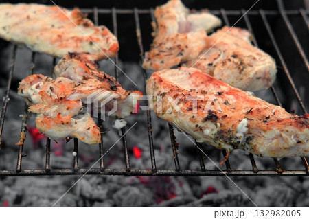 Chicken Fillet Bbq. Grilled Chicken Breast on the hot Grill with Smoke and Fire Flames. Juicy White Meat Steak. Delicious Poultry Roasted Cooked on a Charcoal Barbecue. Camping Food. Outdoors Cooking 132982005