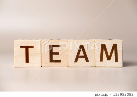 The word TEAM on wooden cubes on a beige neutral studio background. Copy Space. Written. Text words matter. Teamwork, Ideas for business corporation concept. Inspiration for Creation group Brainstorm 132982082