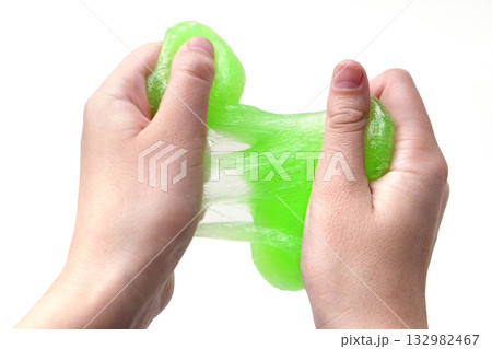 Hand Playing with textured slime on white background. Teen hand holding green shining slime with bubbles, stretching gooey substance. Teenage Girl squeezing slime toy to the sides. Liquid toy. Handgum Hand Playing with textured slime on white background. Teen hand holding green shining slime with bubbles, stretching gooey substance. Teenage Girl squeezing slime toy to the sides. Liquid toy. Handgum 132982467