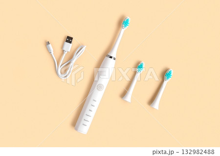Electric Toothbrush. Top View, Flat Lay, Copy Space. Dental Care Supplies on Beige Pastel Studio Background. Oral Hygiene, Gum Health, Healthy Teeth. Modern Dental Ultrasonic Vibration Tooth Brush Set 132982488